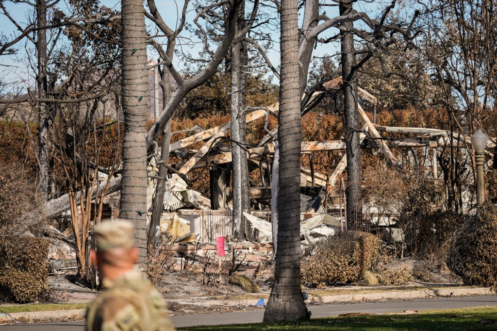 A member of the National Guard stands at a checkpoint while President Donald Trump will visit damage to the Palisades fire area in the Pacific Palisades neighborhood of Los Angeles on Friday, January. 24, 2025.